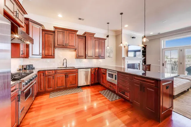 a large kitchen with stainless steel appliances granite countertop a stove a sink dishwasher and a refrigerator