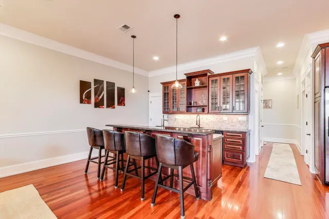 a view of a dining room and livingroom with furniture wooden floor a chandelier