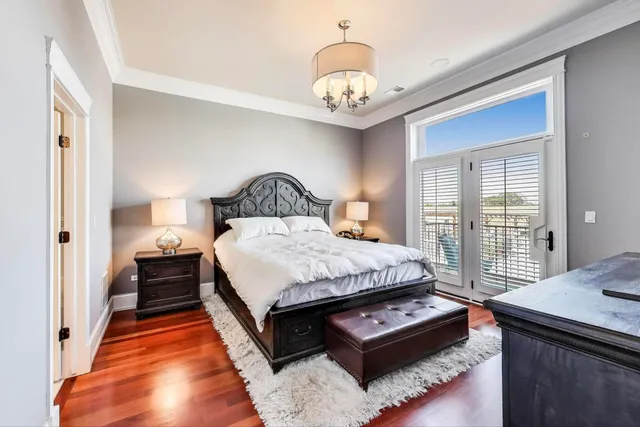 a spacious bedroom with a bed a window and a chandelier