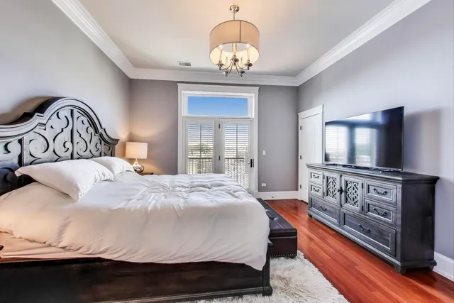 a bedroom with a large bed and a chandelier