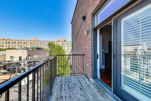 a view of a balcony with wooden floor and fence