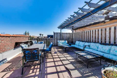 a roof deck with a table and chairs