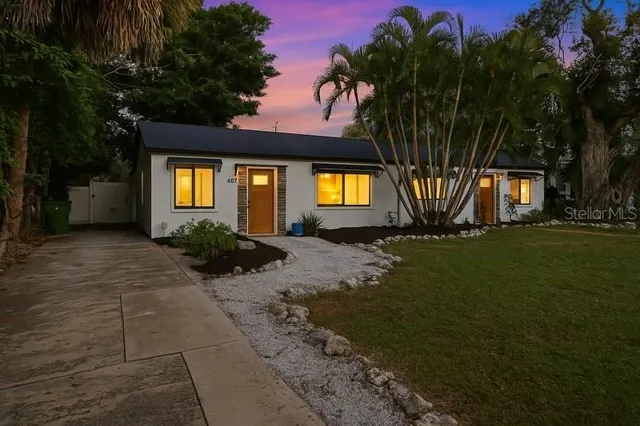 a front view of a house with a garden and yard