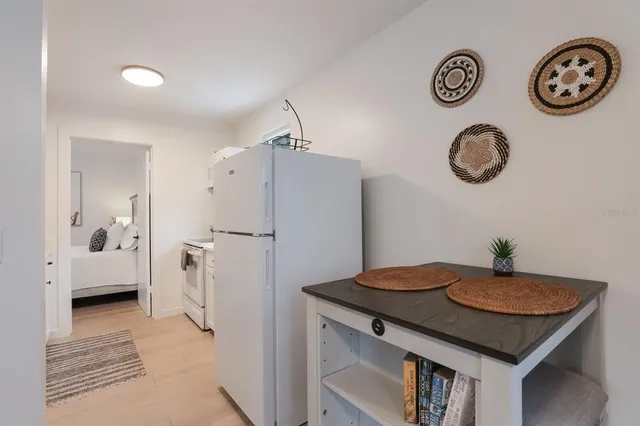 a view of kitchen island with furniture and refrigerator