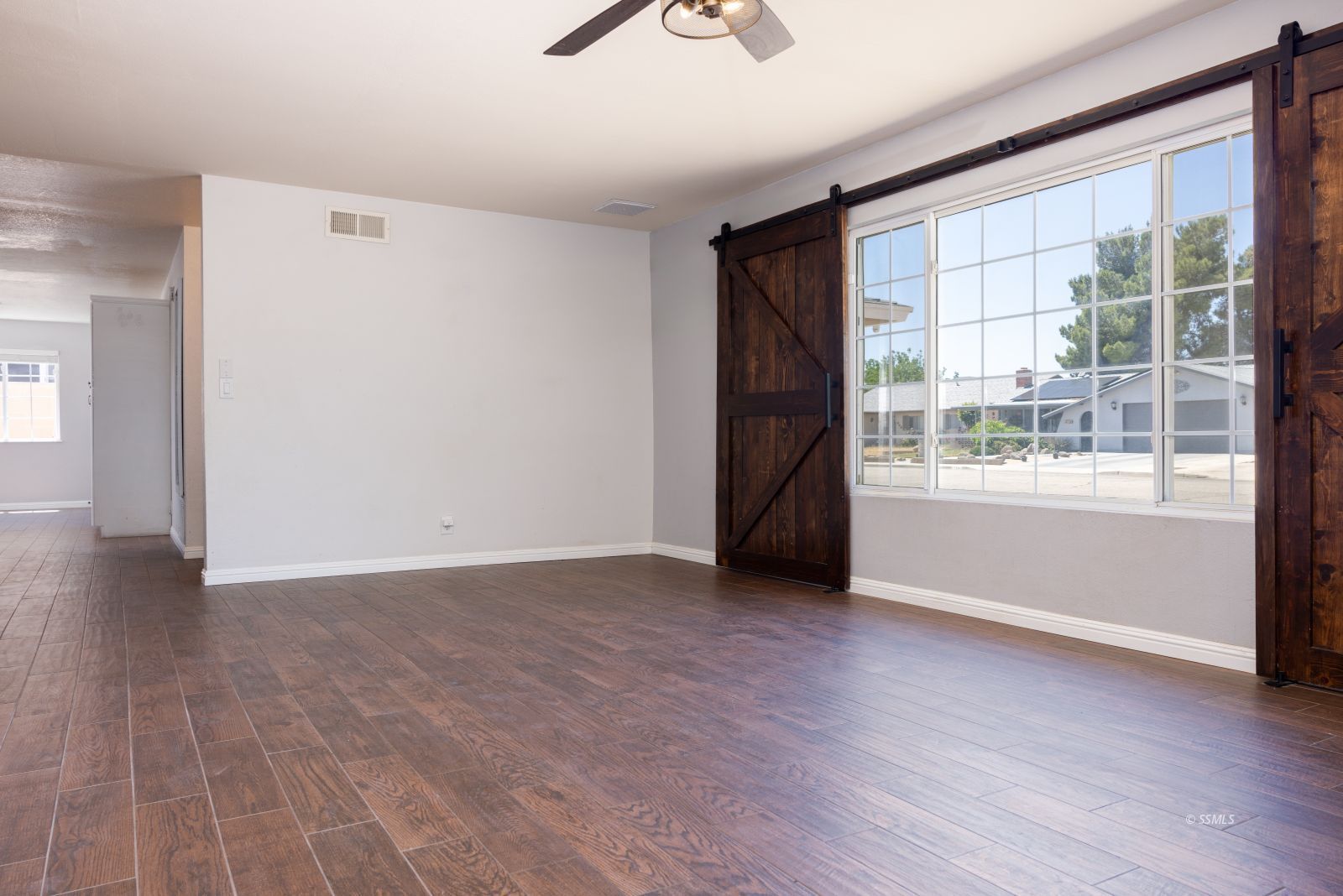 542 South Warner Street Ridgecrest, CA 93555 - Photo 7 of 33 a view of an empty room with wooden floor and a window