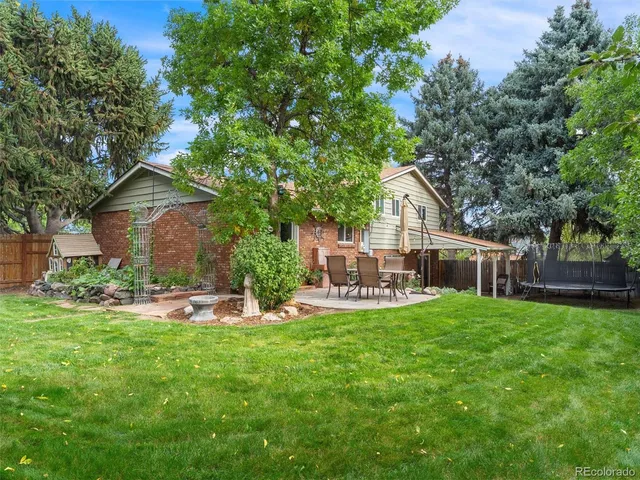 a view of a house with backyard and sitting area