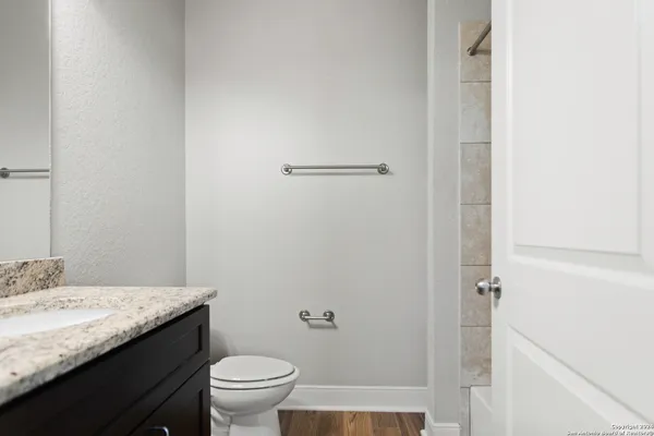 a bathroom with a granite countertop sink toilet and a mirror