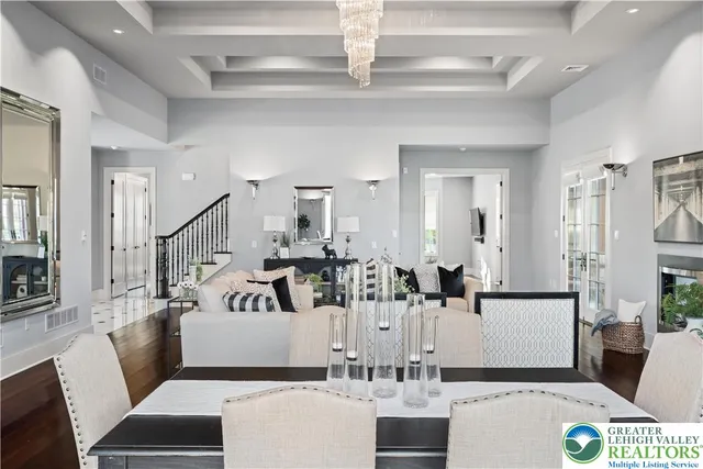 a kitchen with stainless steel appliances granite countertop a stove top oven a refrigerator a sink and chairs