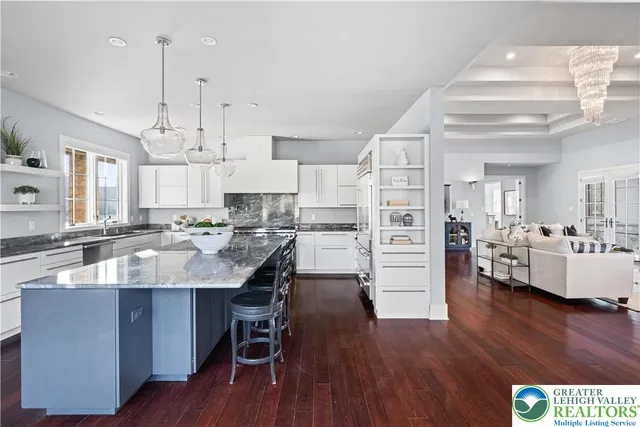 a kitchen with granite countertop a stove and white cabinets