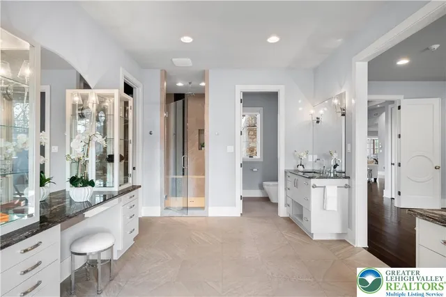 a spacious bathroom with a granite countertop sink a mirror and a vanity