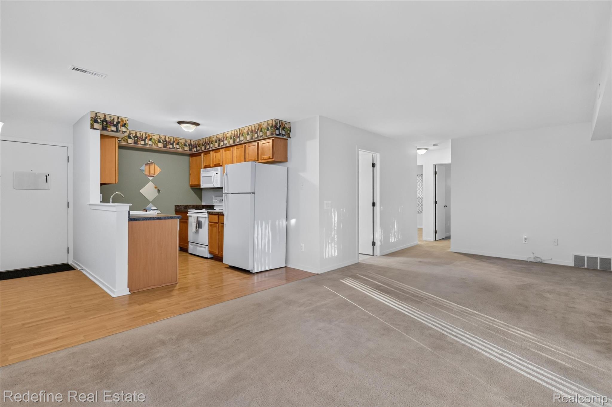 27971 Rollcrest Road, Unit 9 Farmington, MI 48334 - Photo 6 of 25 Open-concept living area featuring a kitchen with wood cabinetry, a built-in oven/range, and a refrigerator