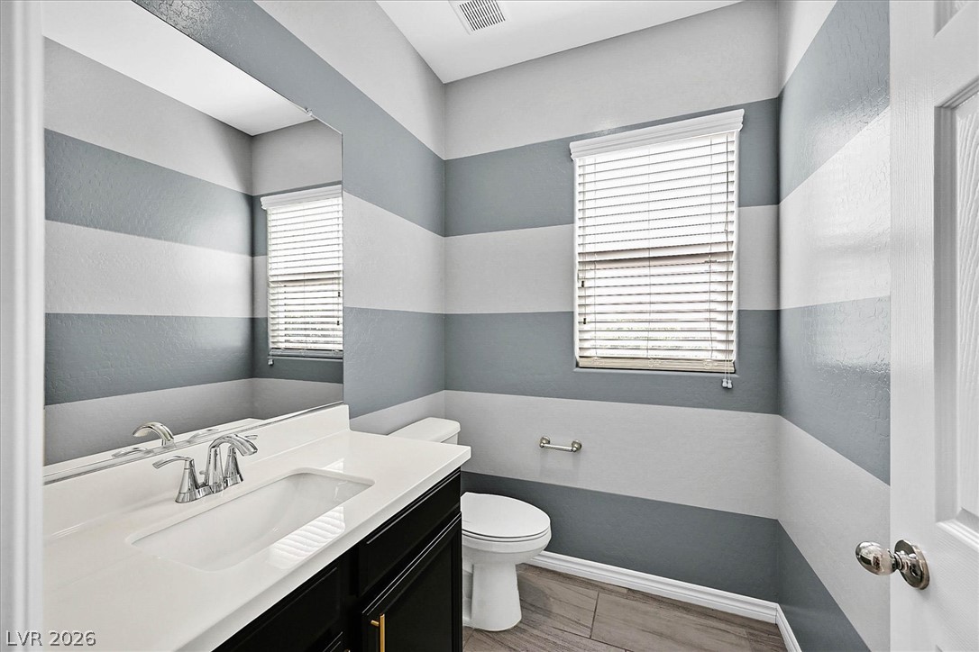 1106 Langston Ranch Avenue Henderson, NV 89002 - Photo 11 of 36 A well-lit half bathroom offers a clean vanity with a large mirror and a window with privacy blinds.