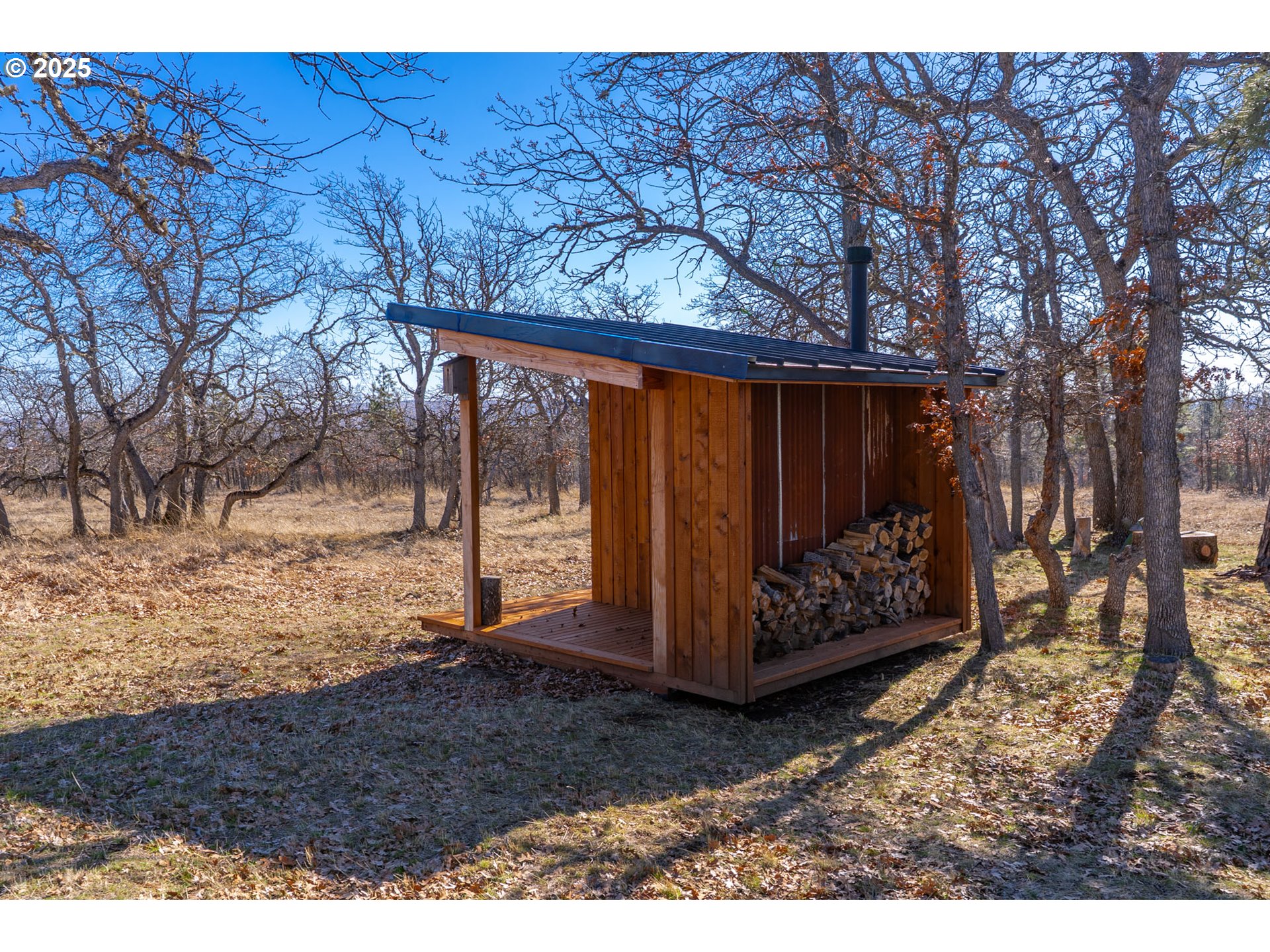 76 Big Springs Road Goldendale, WA 98620 - Photo 22 of 48 a view of a backyard with large trees and wooden fence