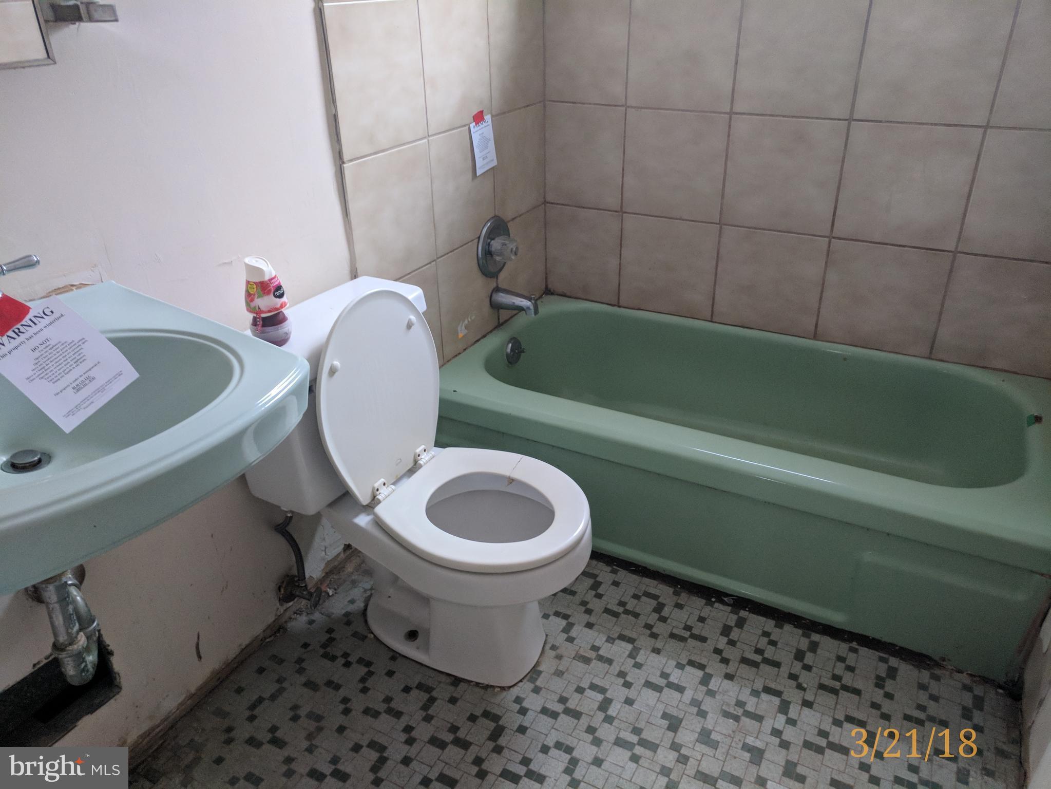 4452 Scotia Road Baltimore, MD 21227 - Photo 14 of 20 a bathroom with a toilet sink and mirror