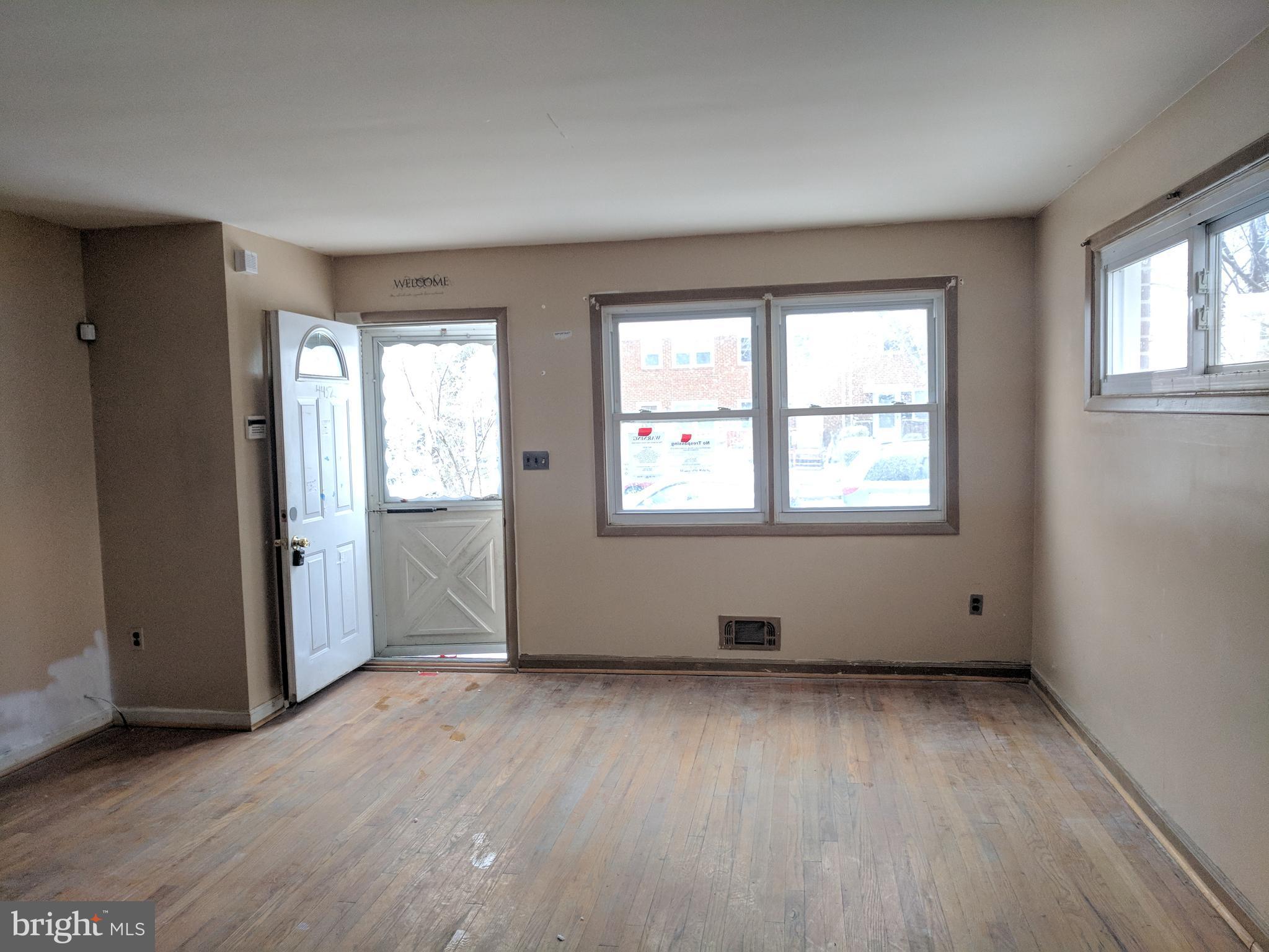 4452 Scotia Road Baltimore, MD 21227 - Photo 6 of 20 an empty room with wooden floor and windows