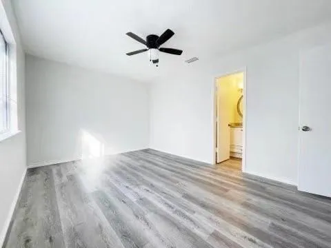 a view of empty room with wooden floor and windows