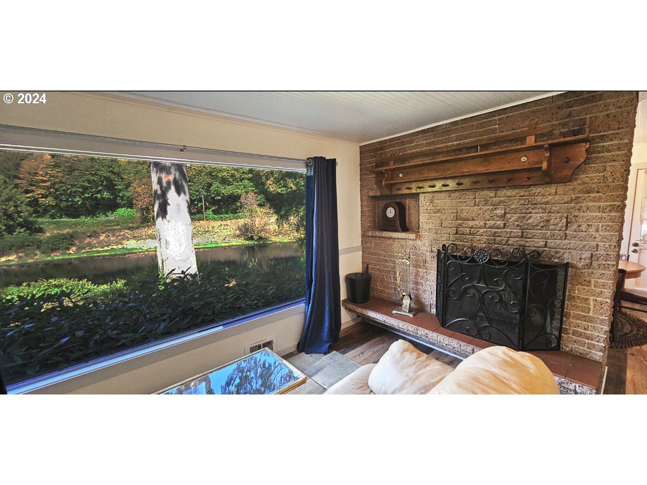 11354 Highway 36 Mapleton, OR 97453 - Photo 9 of 15 a living room with a fireplace and a floor to ceiling window