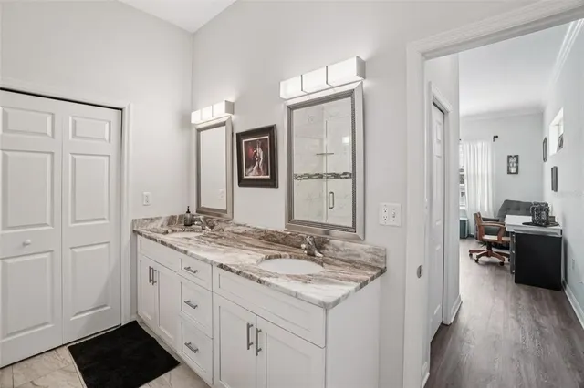 a en suite bathroom with a granite countertop sink and a mirror