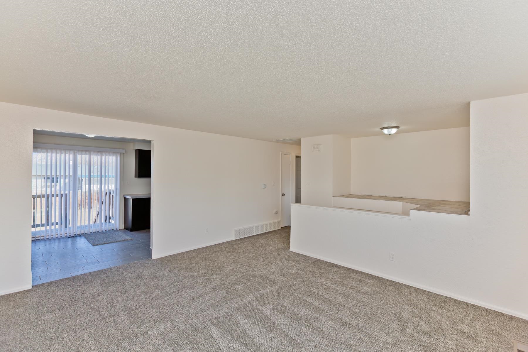 3212 D D 1/4 Road Clifton, CO 81520 - Photo 2 of 25 a view of an empty room with wooden floor and windows