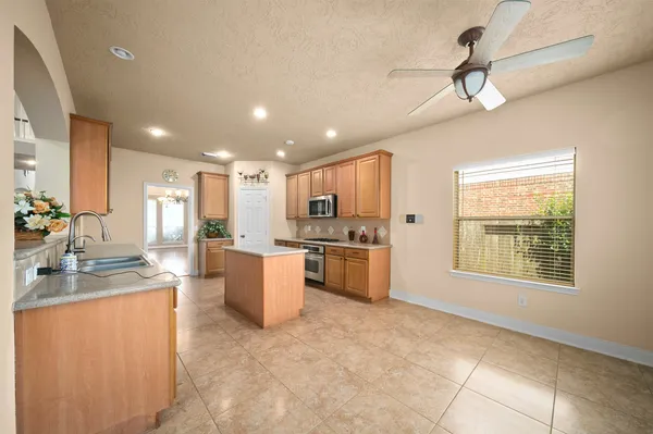 a large kitchen with a large counter top appliances and cabinets
