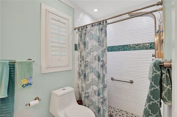 a bathroom with a toilet and shower curtain