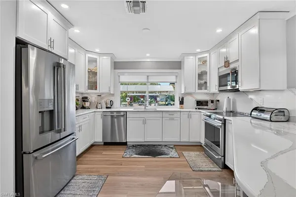 a kitchen with a refrigerator a sink and cabinets