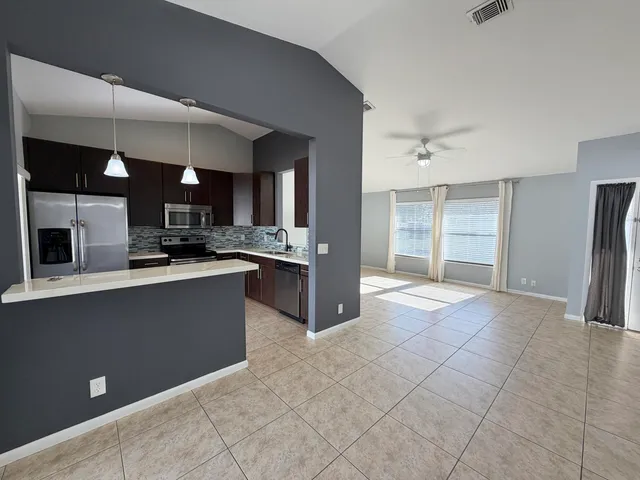 a kitchen with stainless steel appliances granite countertop a refrigerator and a sink