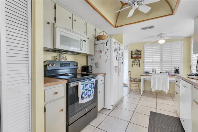 a kitchen with stainless steel appliances a sink a stove a refrigerator cabinets and dining table