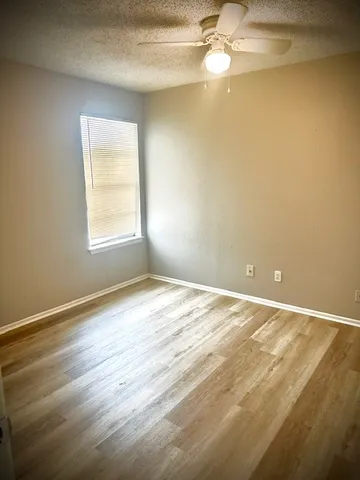 an empty room with a window and wooden floor