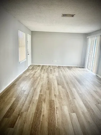 a view of an empty room and wooden floor