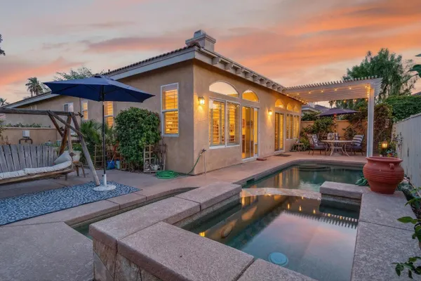 a view of a house with swimming pool and sitting area