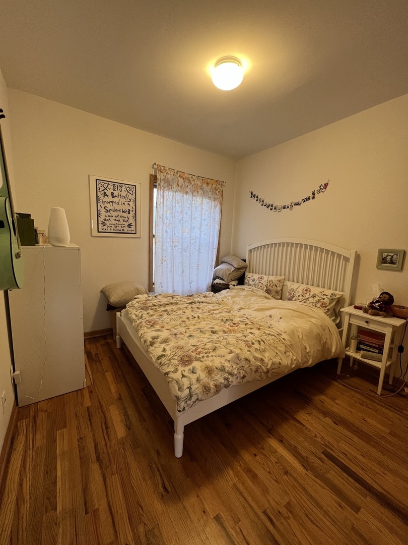 626 West Patterson Avenue, Unit 2E Chicago, IL 60613 - Photo 6 of 9 a bedroom with a bed and wooden floor