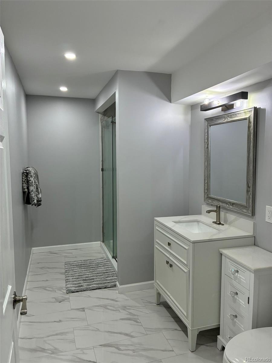 7242 South Rome Street Aurora, CO 80016 - Photo 20 of 33 a bathroom with a sink and mirror