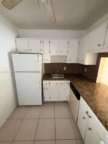 a kitchen with granite countertop white cabinets and white appliances