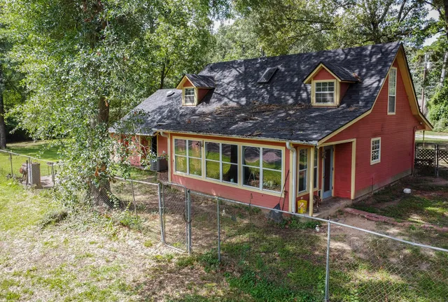 a backyard of a house with table and chairs under an umbrella