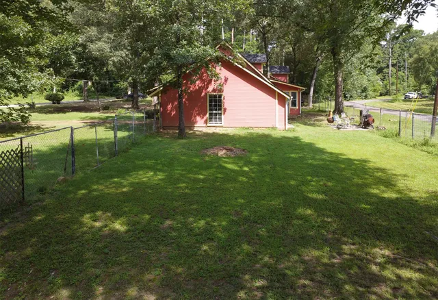 an aerial view of residential house with outdoor space and trees all around