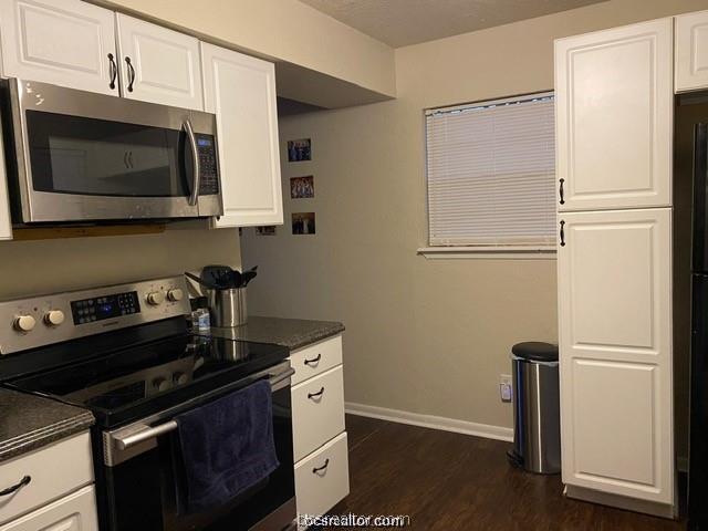 3005 1st Street Bryan, TX 77801 - Photo 4 of 18 a kitchen with stainless steel appliances granite countertop a stove microwave and refrigerator