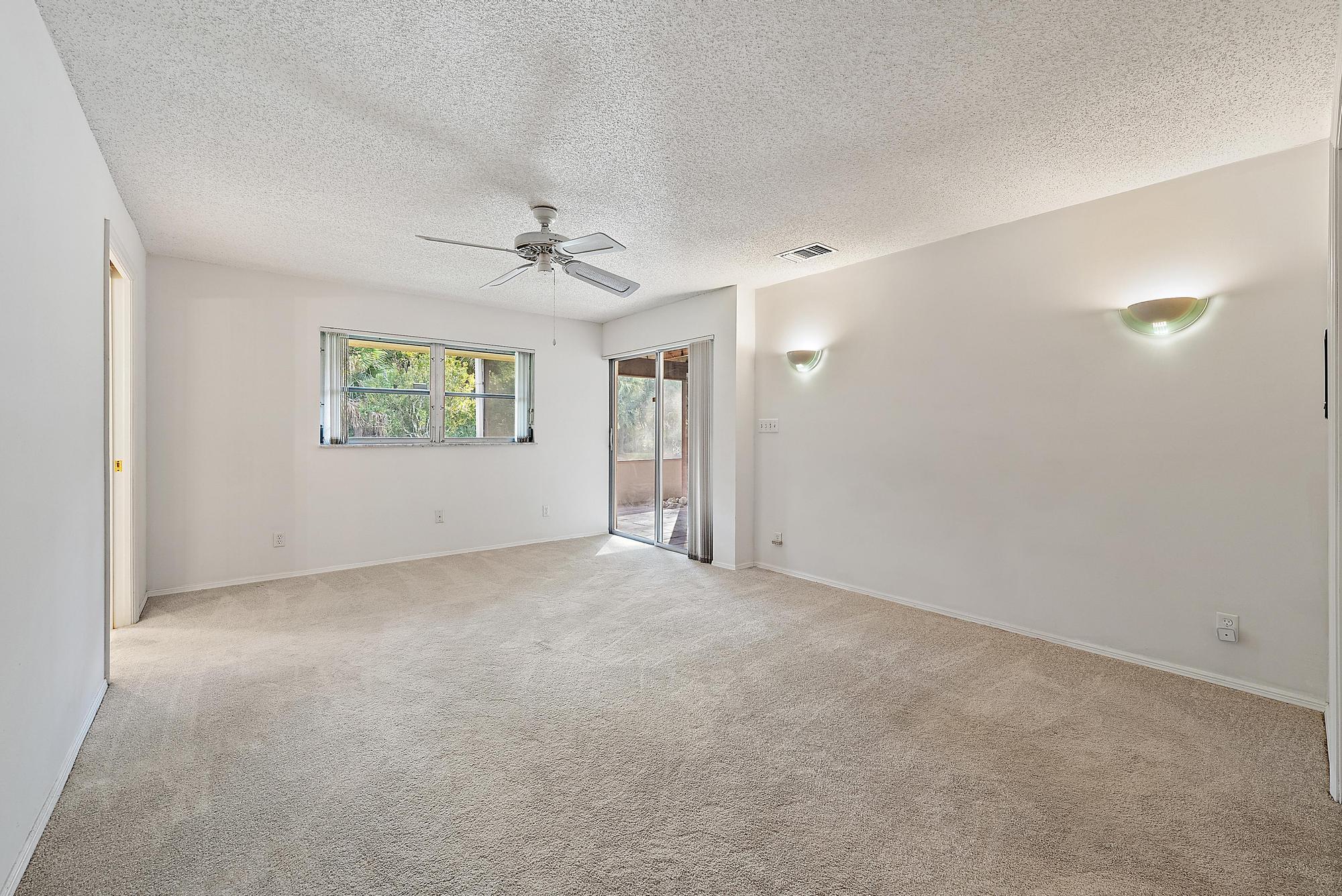 16486 95th Avenue North Jupiter, FL 33478 - Photo 12 of 34 an empty room with windows and ceiling fan