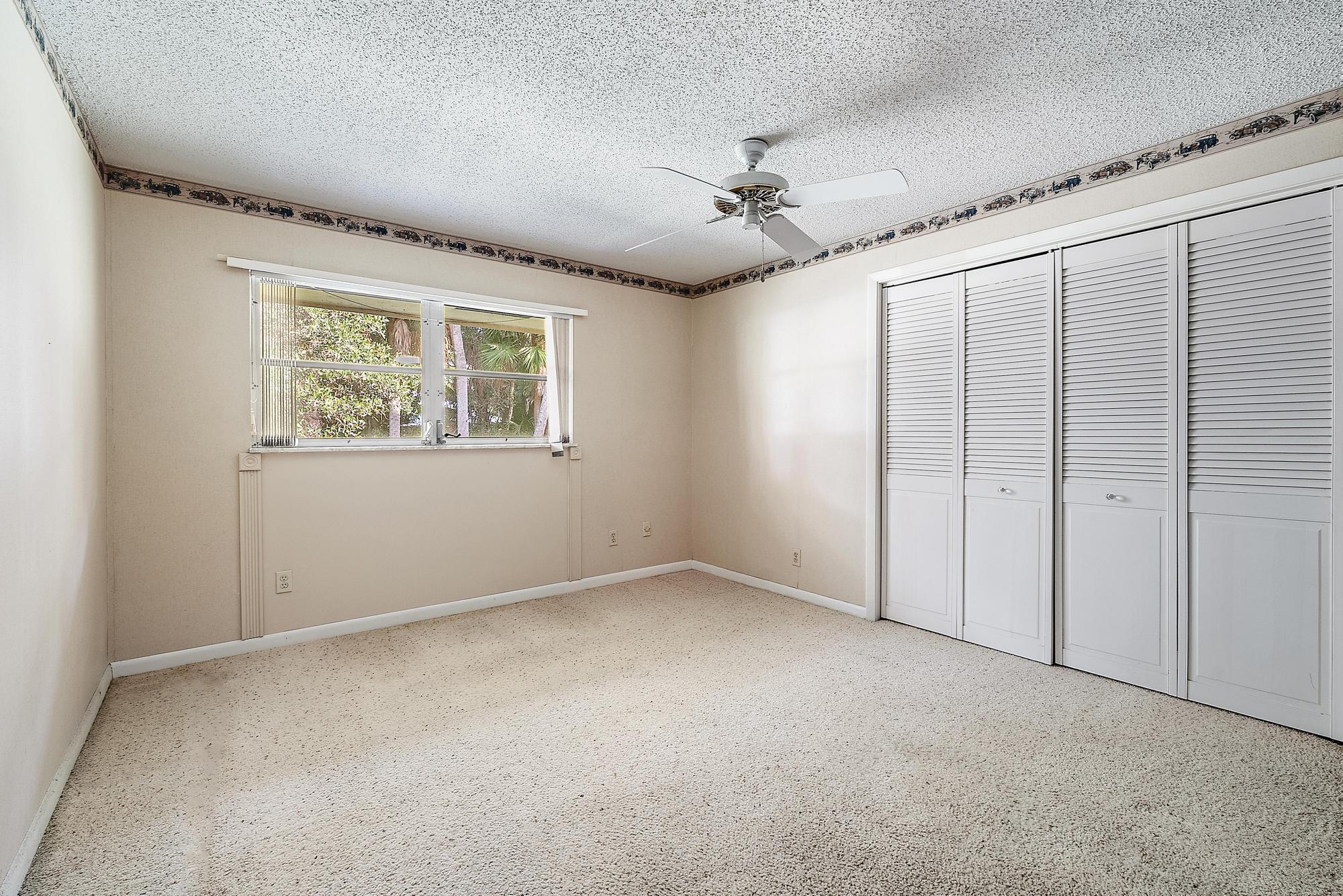 16486 95th Avenue North Jupiter, FL 33478 - Photo 14 of 34 an empty room with windows and fan