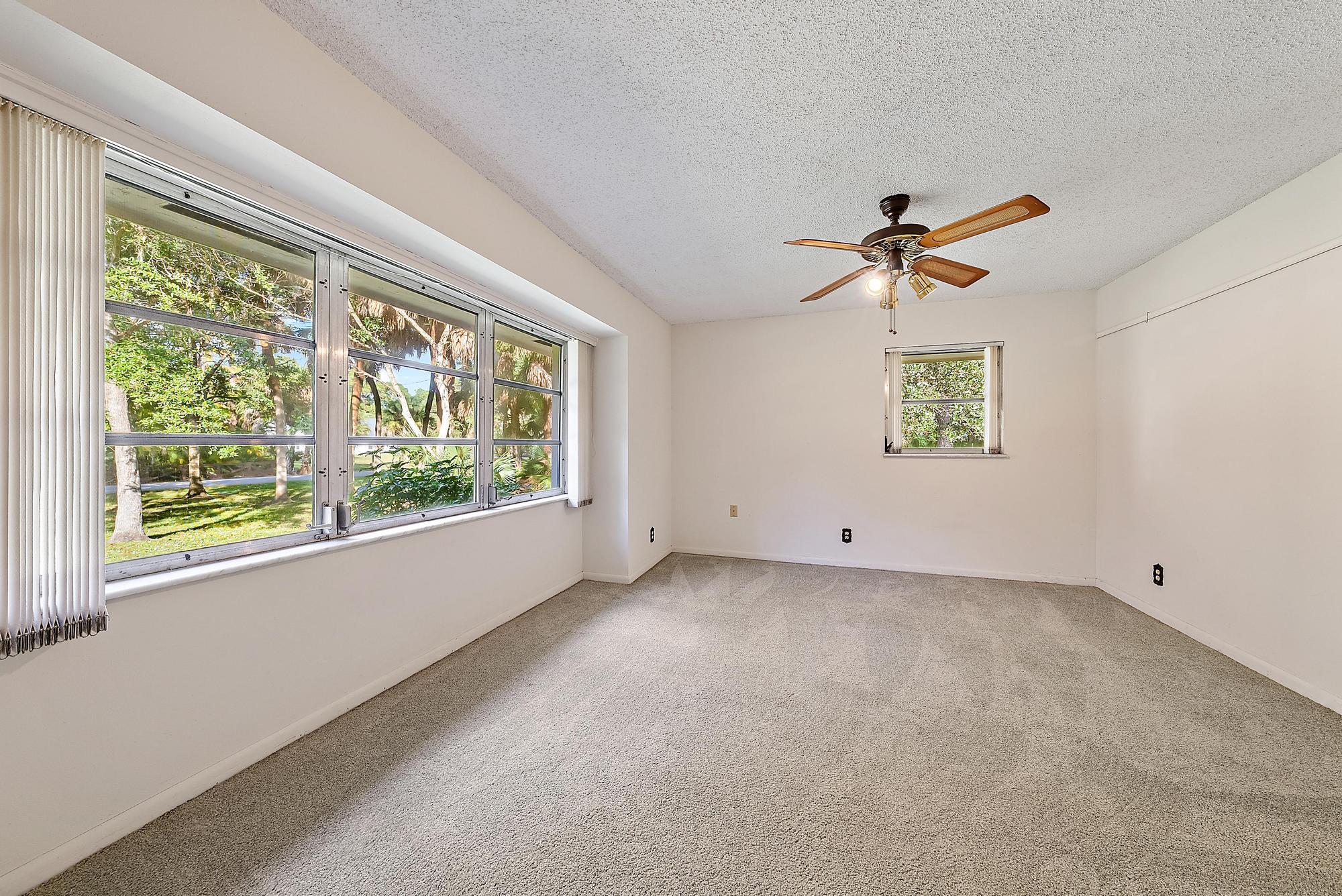 16486 95th Avenue North Jupiter, FL 33478 - Photo 15 of 34 wooden floor in an empty room with a window