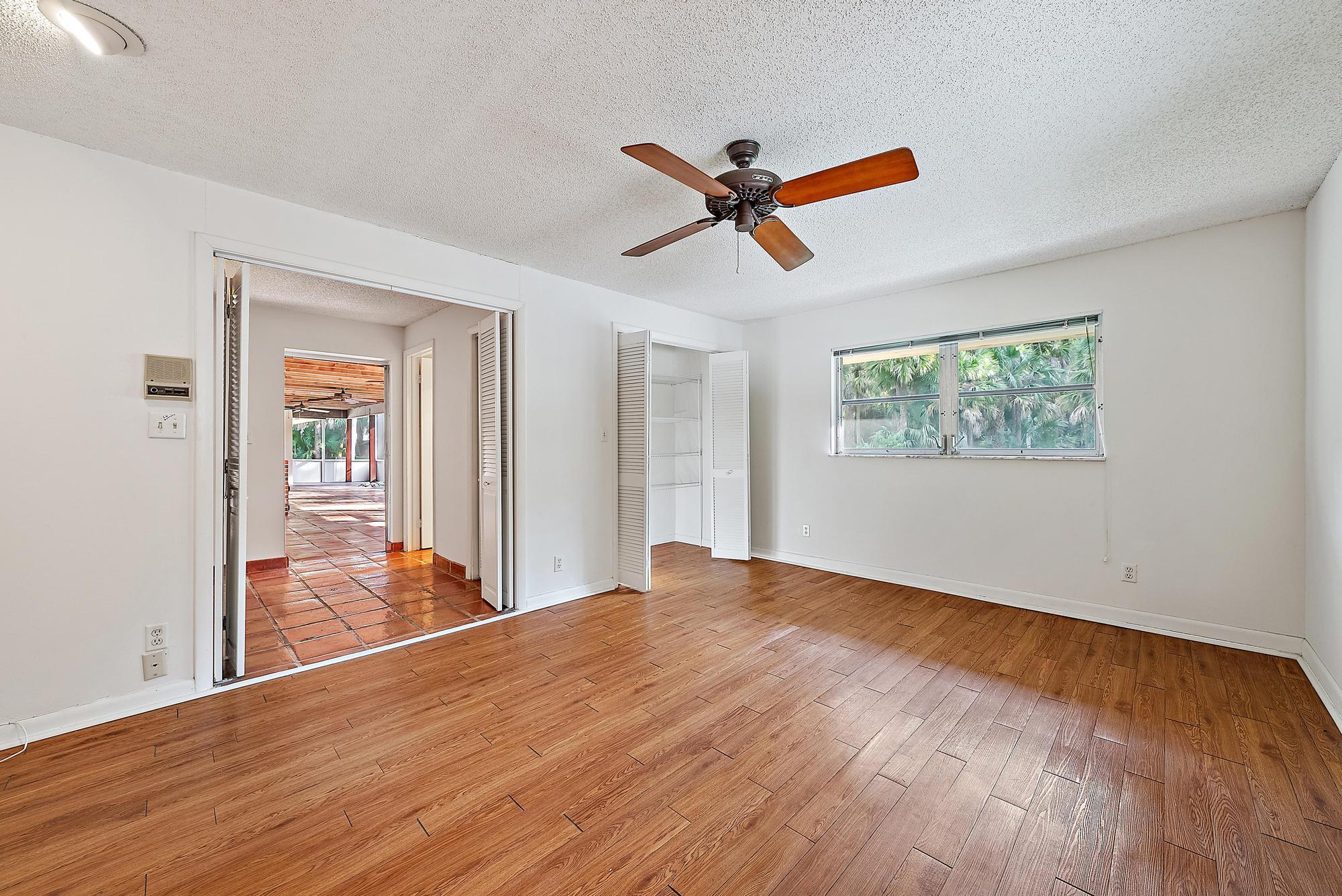 16486 95th Avenue North Jupiter, FL 33478 - Photo 17 of 34 a view of a livingroom with wooden floor and a ceiling fan