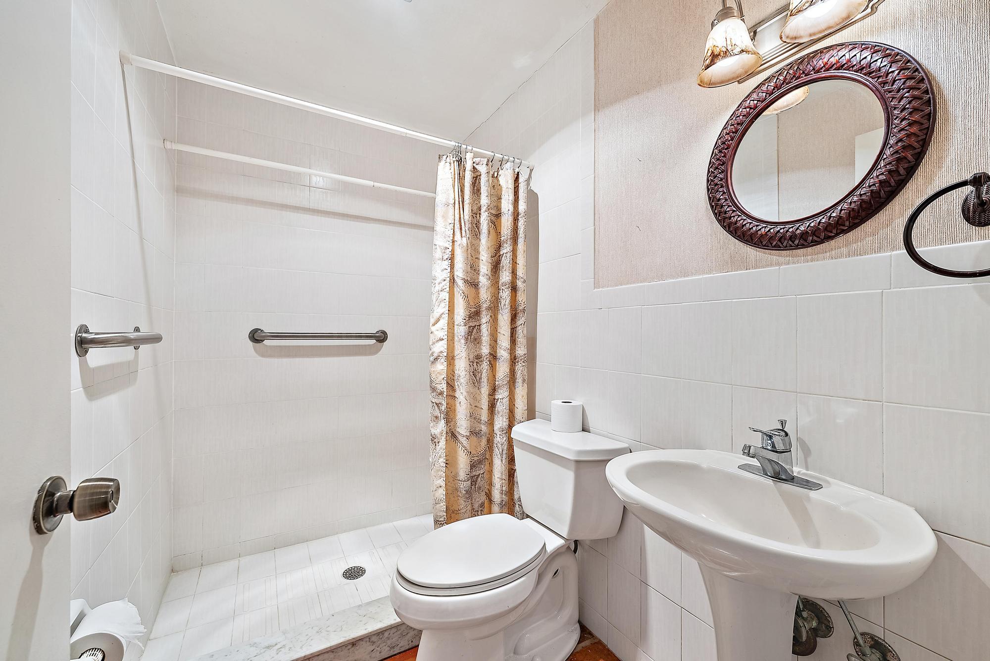 16486 95th Avenue North Jupiter, FL 33478 - Photo 19 of 34 a bathroom with a sink a toilet and a mirror