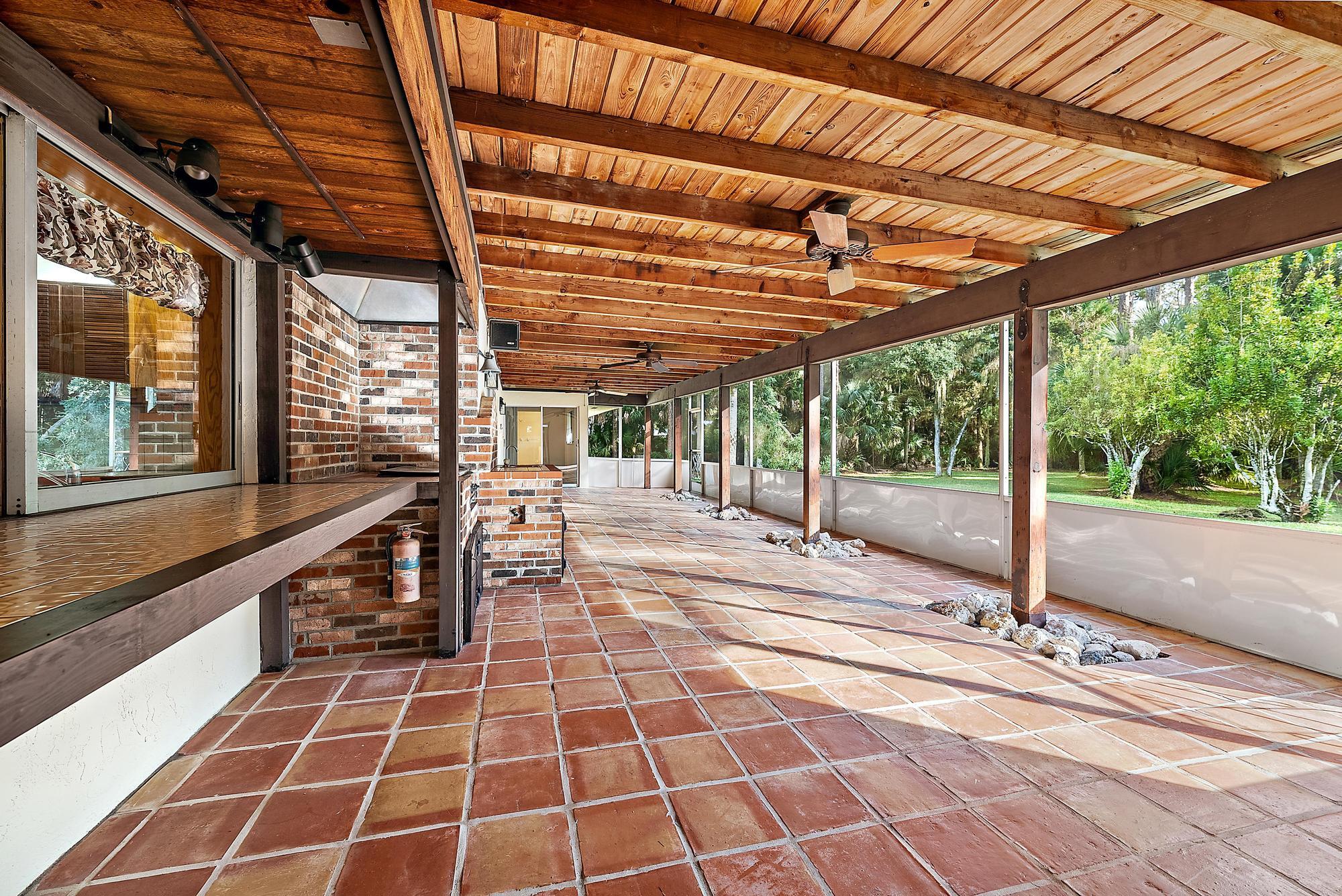 16486 95th Avenue North Jupiter, FL 33478 - Photo 20 of 34 a view of a porch with wooden floor and iron stairs