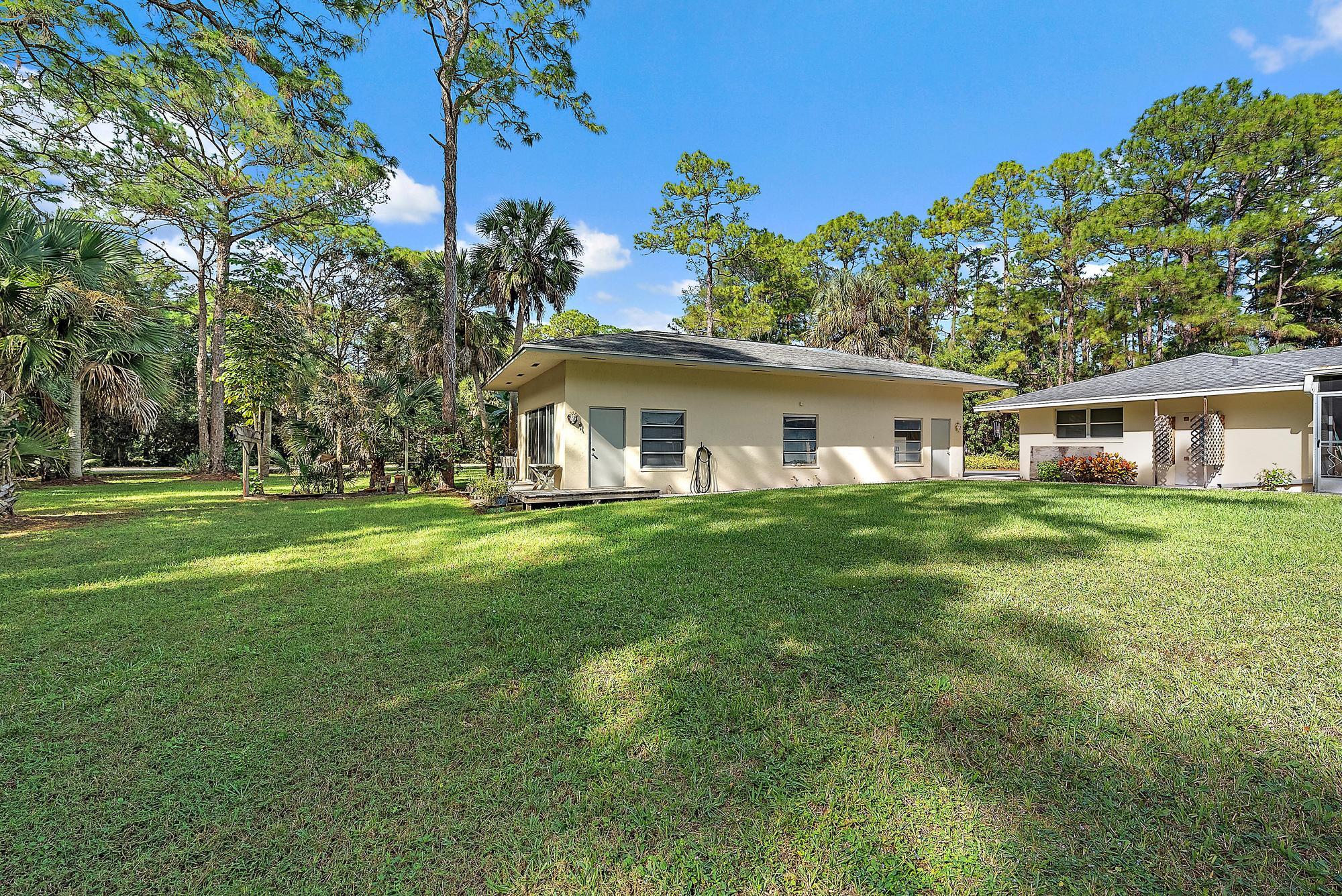 16486 95th Avenue North Jupiter, FL 33478 - Photo 23 of 34 a front view of a house with a garden