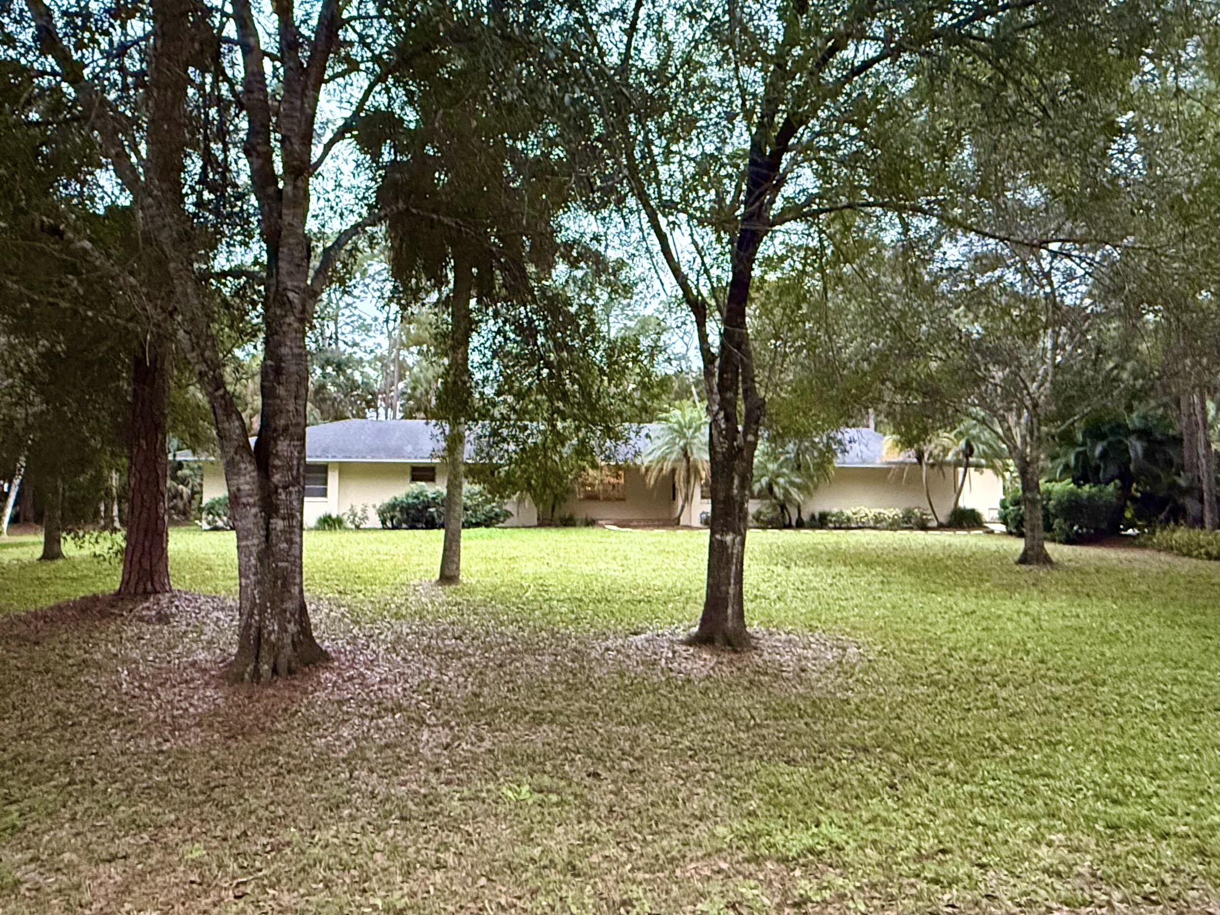 16486 95th Avenue North Jupiter, FL 33478 - Photo 33 of 34 a house that has a tree in front of it