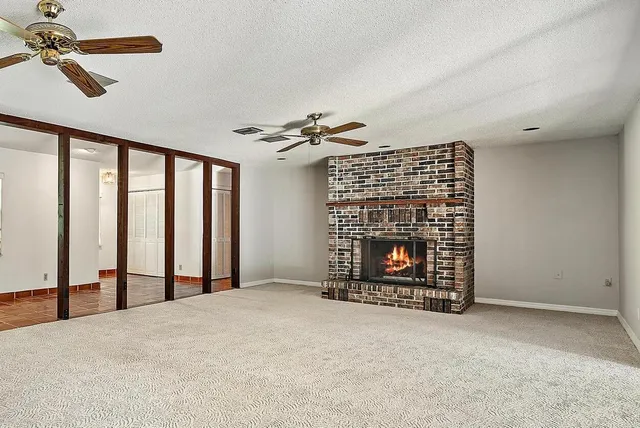 a view of an empty room with a fireplace and a window