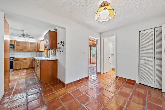 an empty room with closet and a ceiling fan