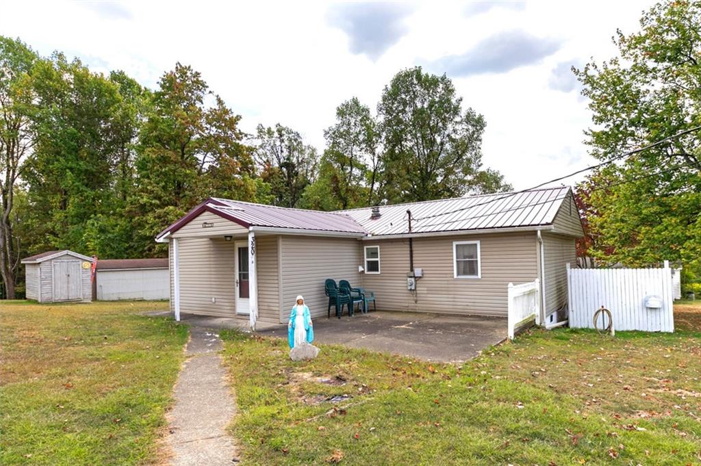 a view of a house with backyard and trees