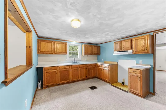 a kitchen with stainless steel appliances granite countertop a sink stove and cabinets