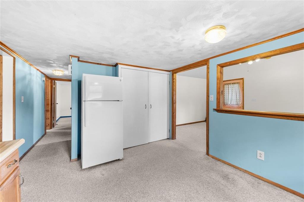 320 Cemetery Road Perryopolis, PA 15473 - Photo 10 of 18 a view of a refrigerator in kitchen and an empty room